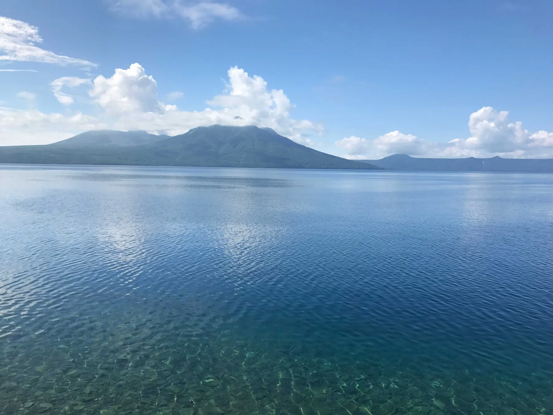 支笏湖の青い湖面と対岸の山並み